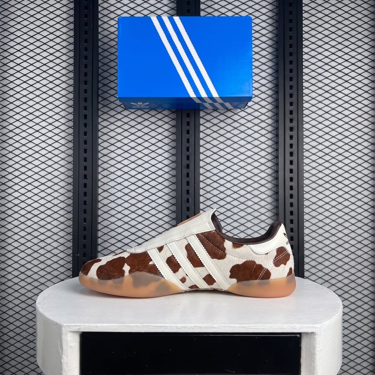 Brown and white cow-print slip-on trainer with gum sole