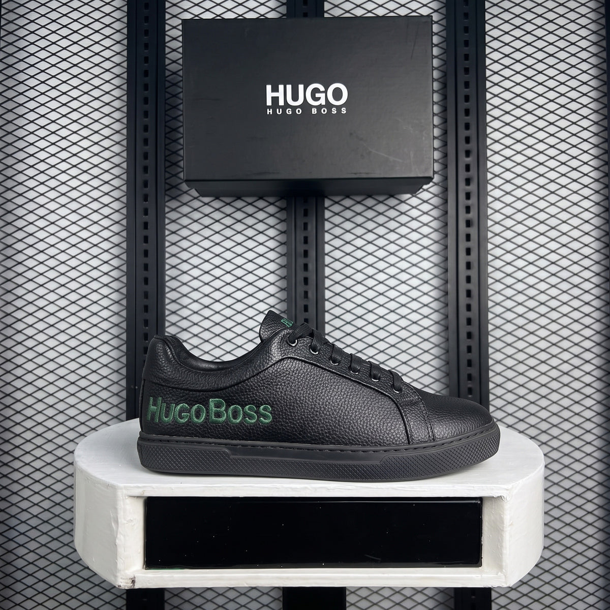 Low-top pebbled leather trainer with green lettering