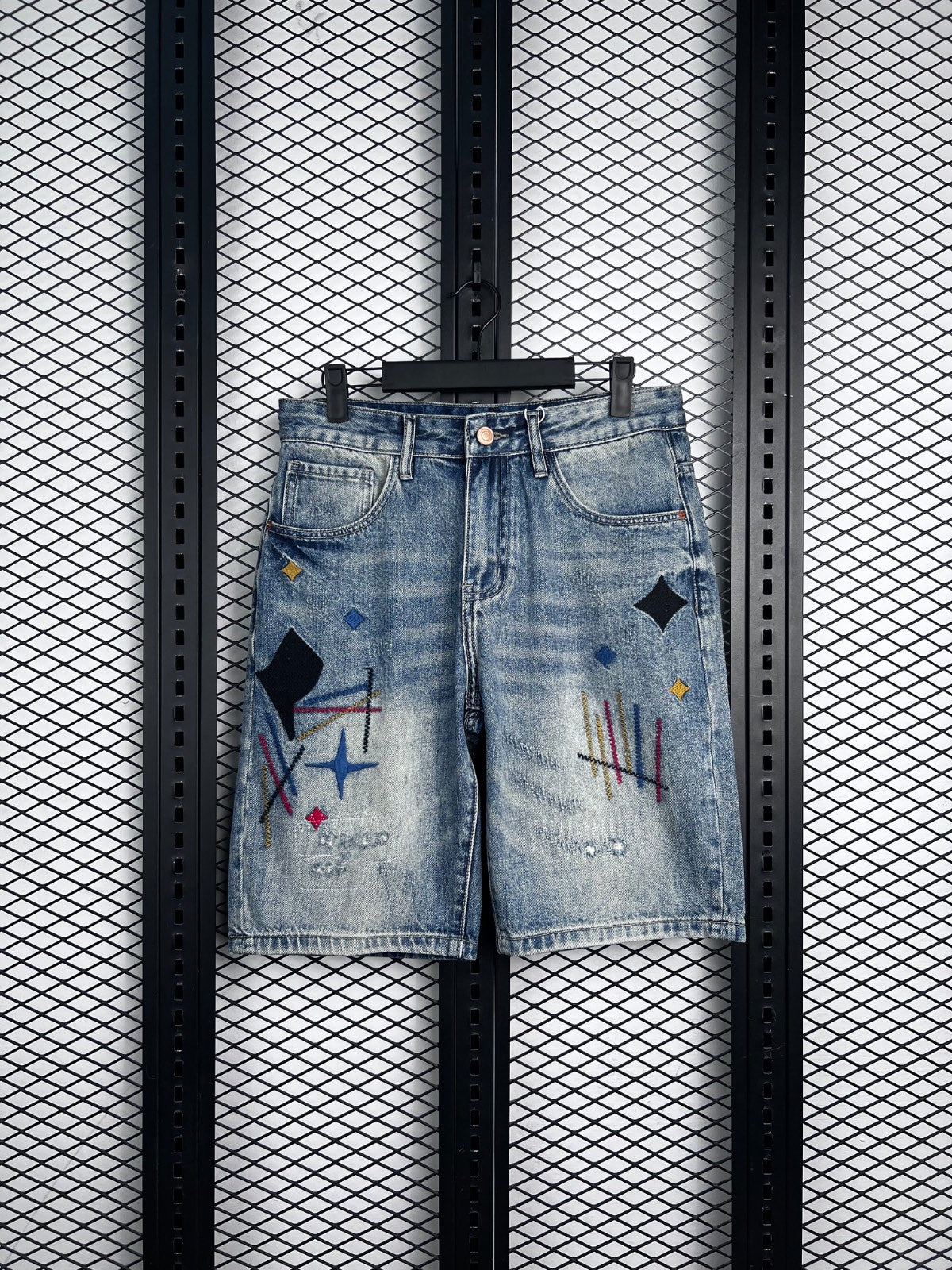 Acid-wash denim shorts with abstract embroidery and patches