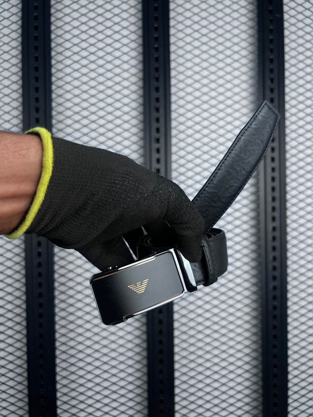 Black leather belt with gold-accented plaque buckle