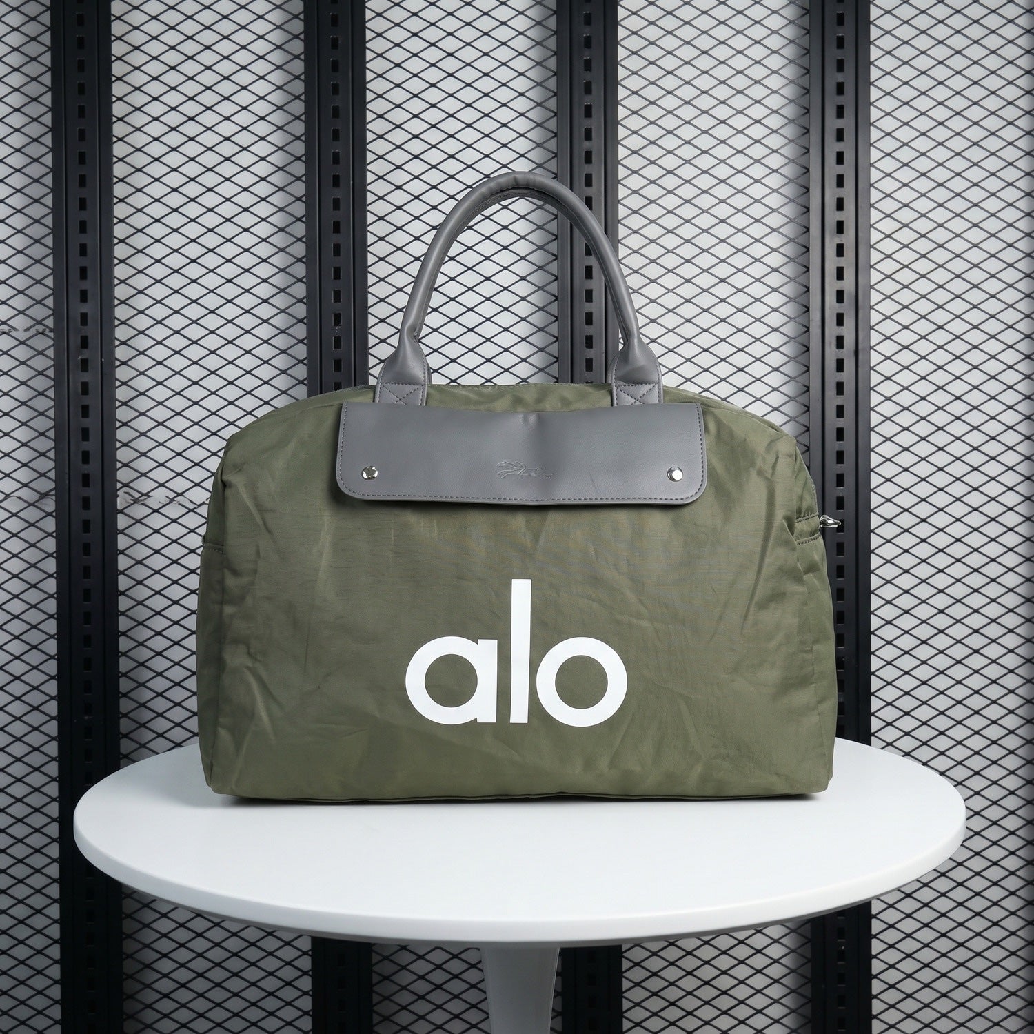 Stud-fastened flap duffel bag in olive nylon