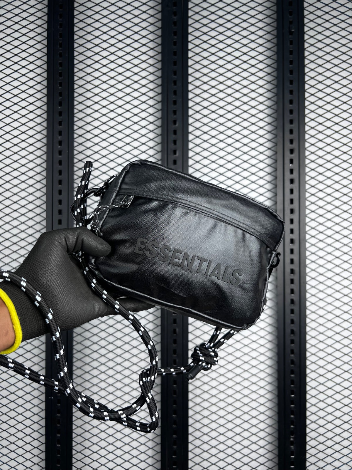 Black coated crossbody bag with patterned cord strap