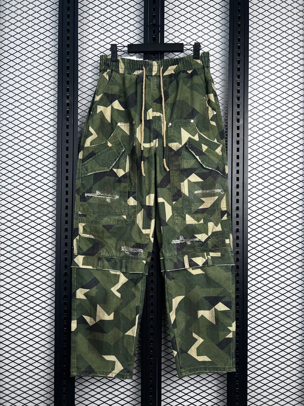 Drawstring-waist geometric camo cargo pants with distressed patches