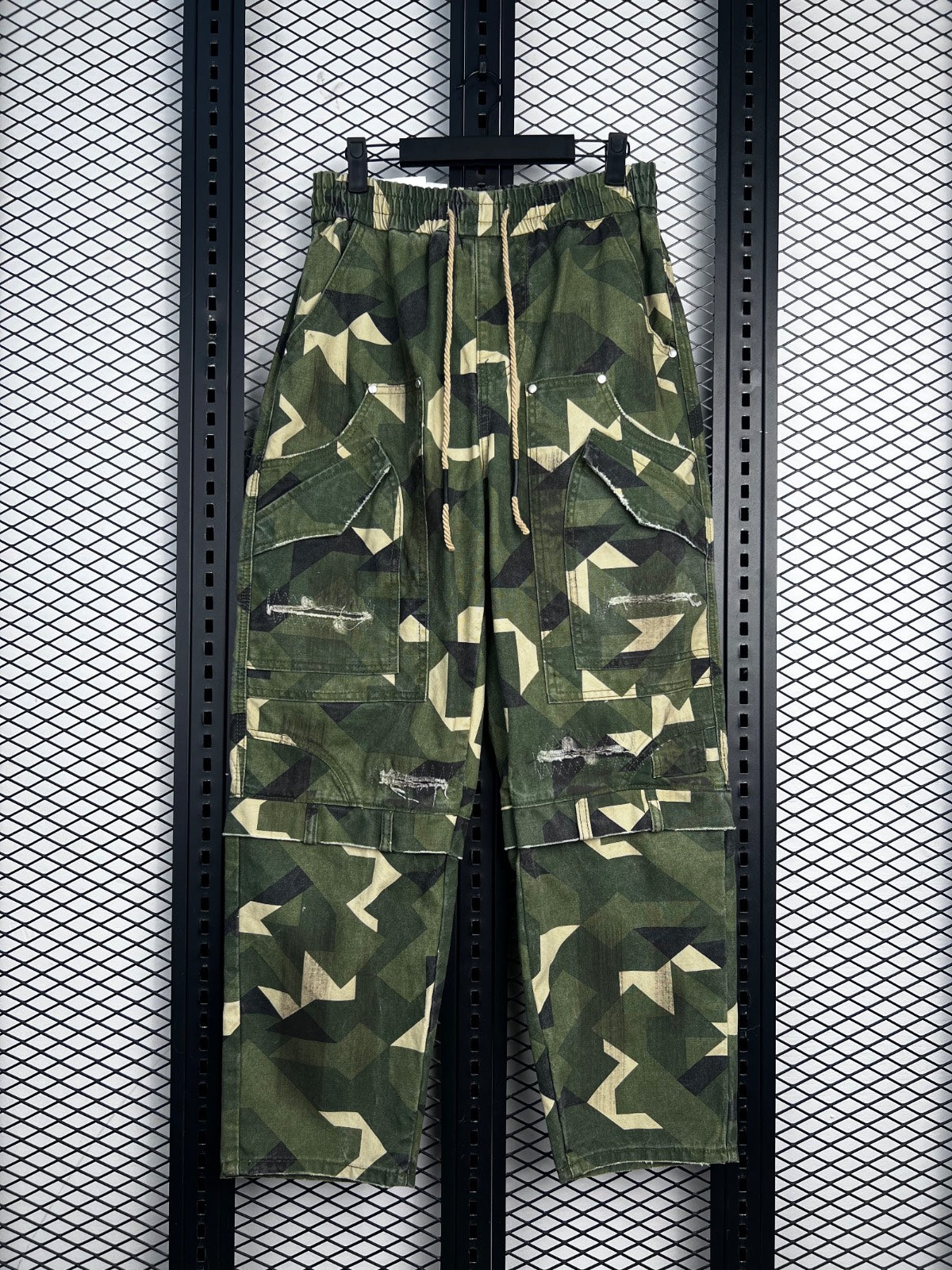Drawstring-waist geometric camo cargo pants with distressed patches